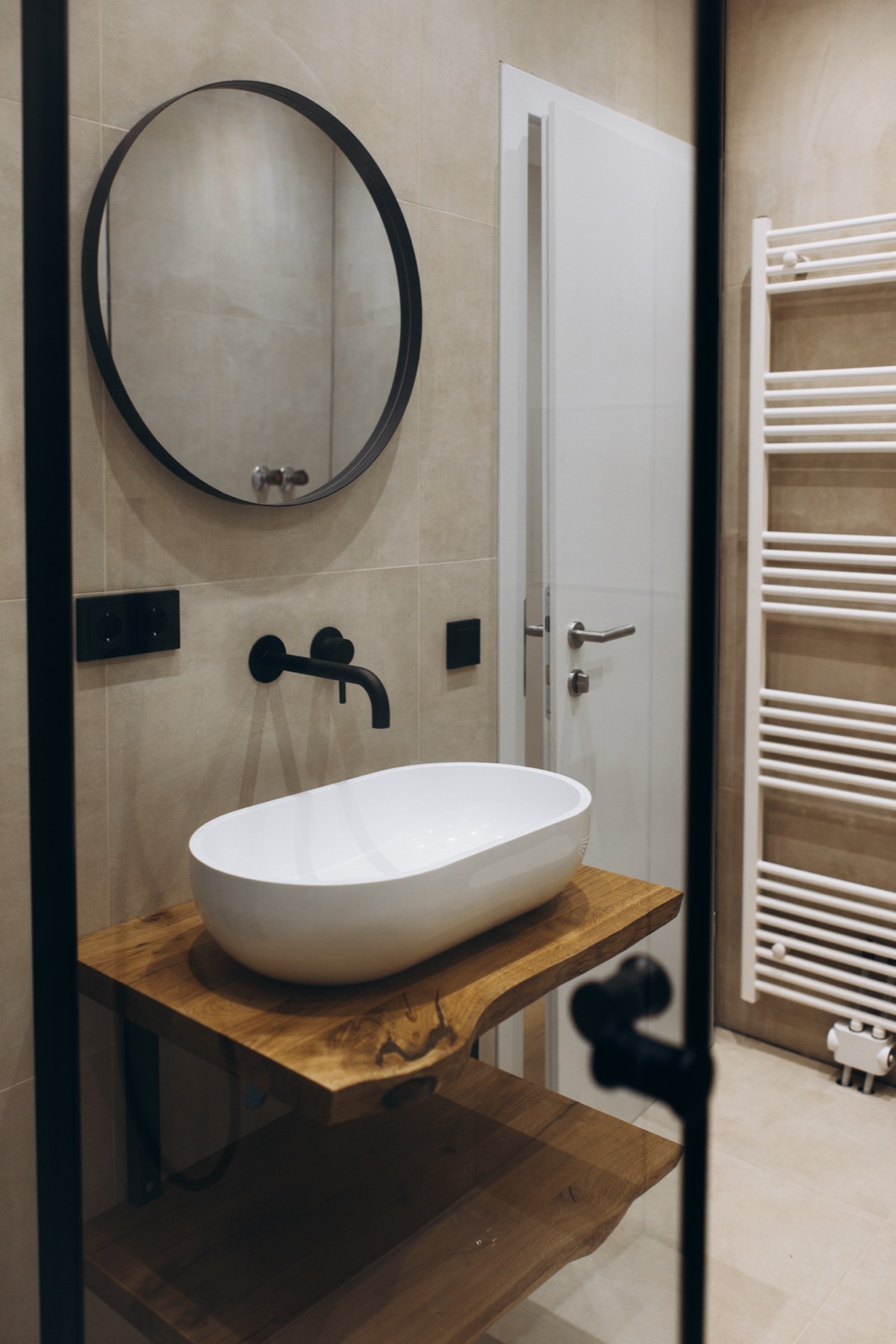 Badezimmer mit Waschbecken und rundem Spiegel