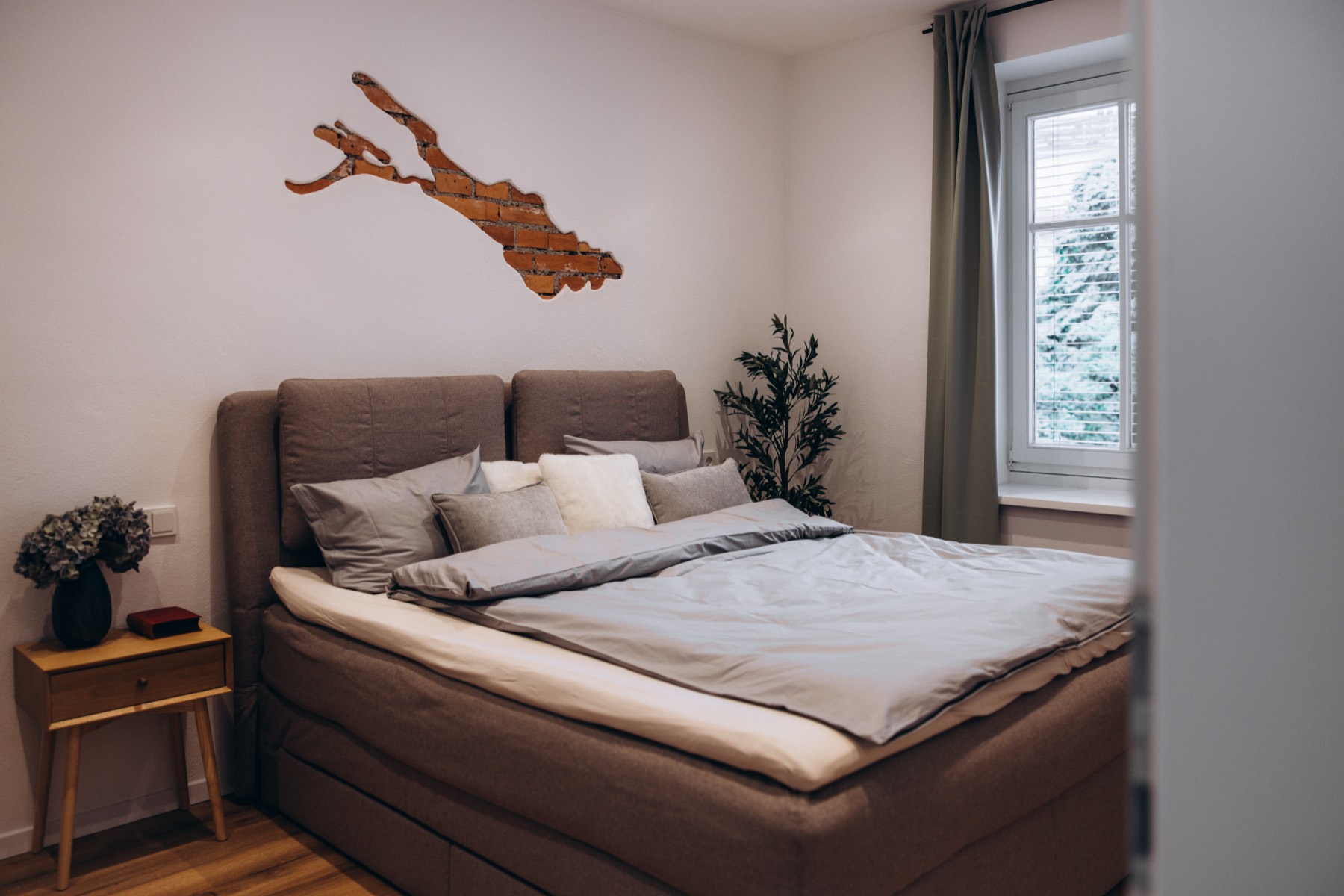 Schlafzimmer mit Doppelbett und Bodensee-Silhouette aus Holz